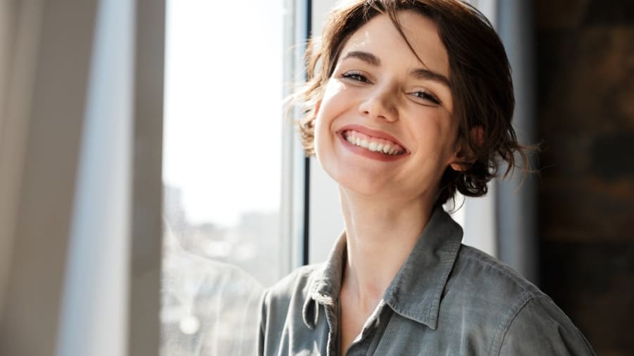 אישה מחייכת אחרי הלבנה לשיניים