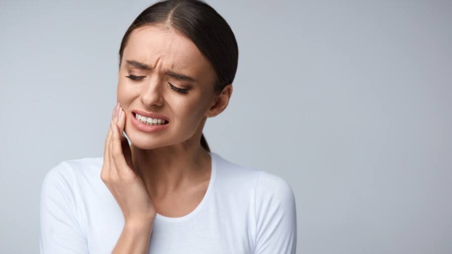 אישה עם כאב שיניים טיפול טבעי בבית