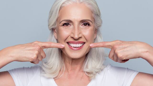 old-woman-poiting-at-her-smile.jpg